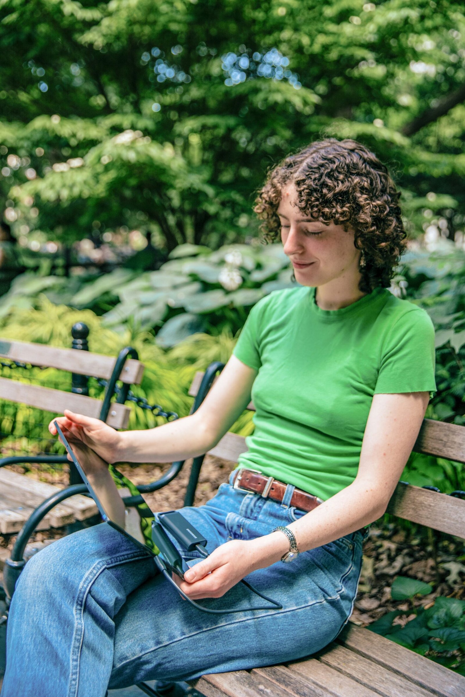 A woman sitting on a wooden bench in a park