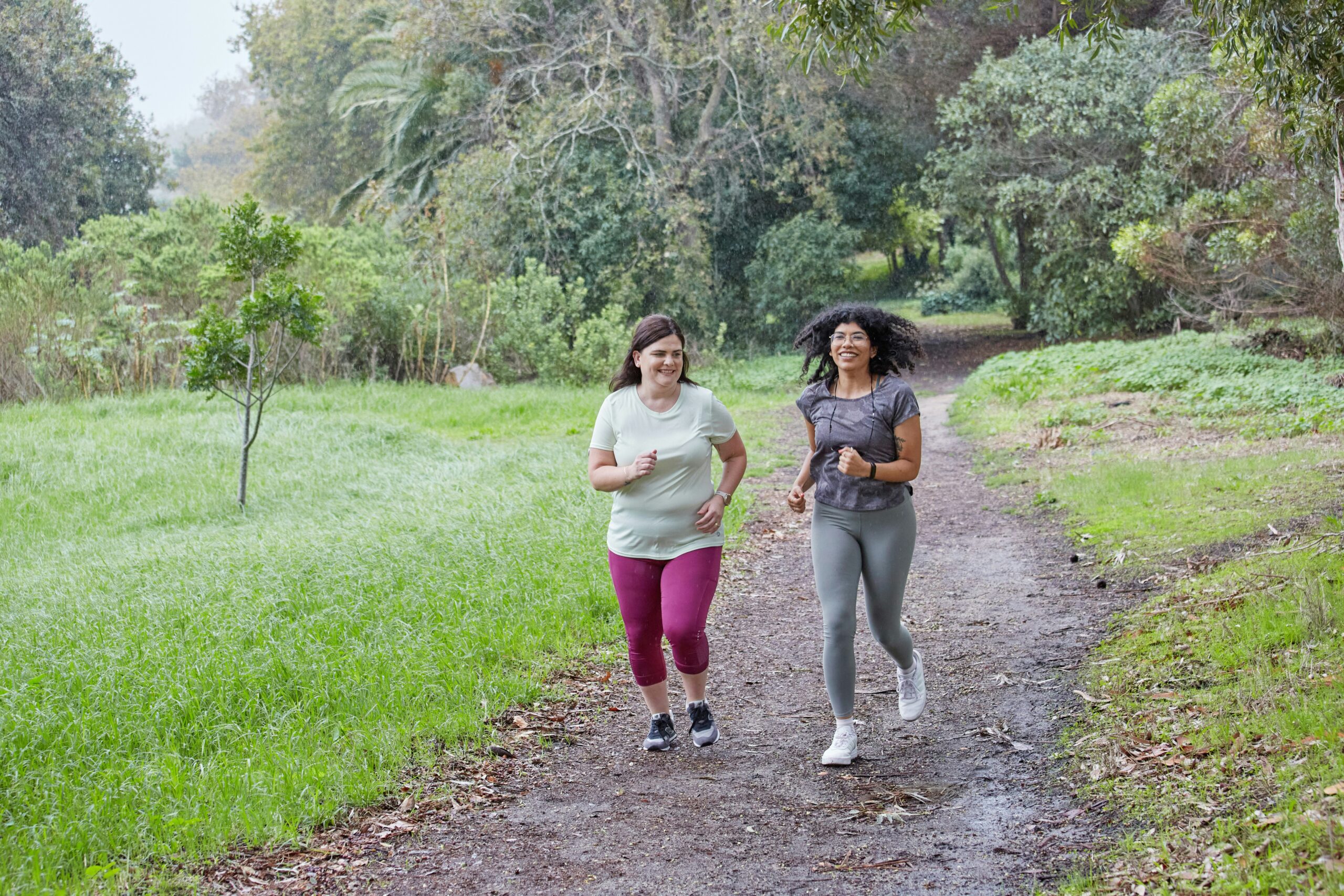 a couple of women running down a dirt road