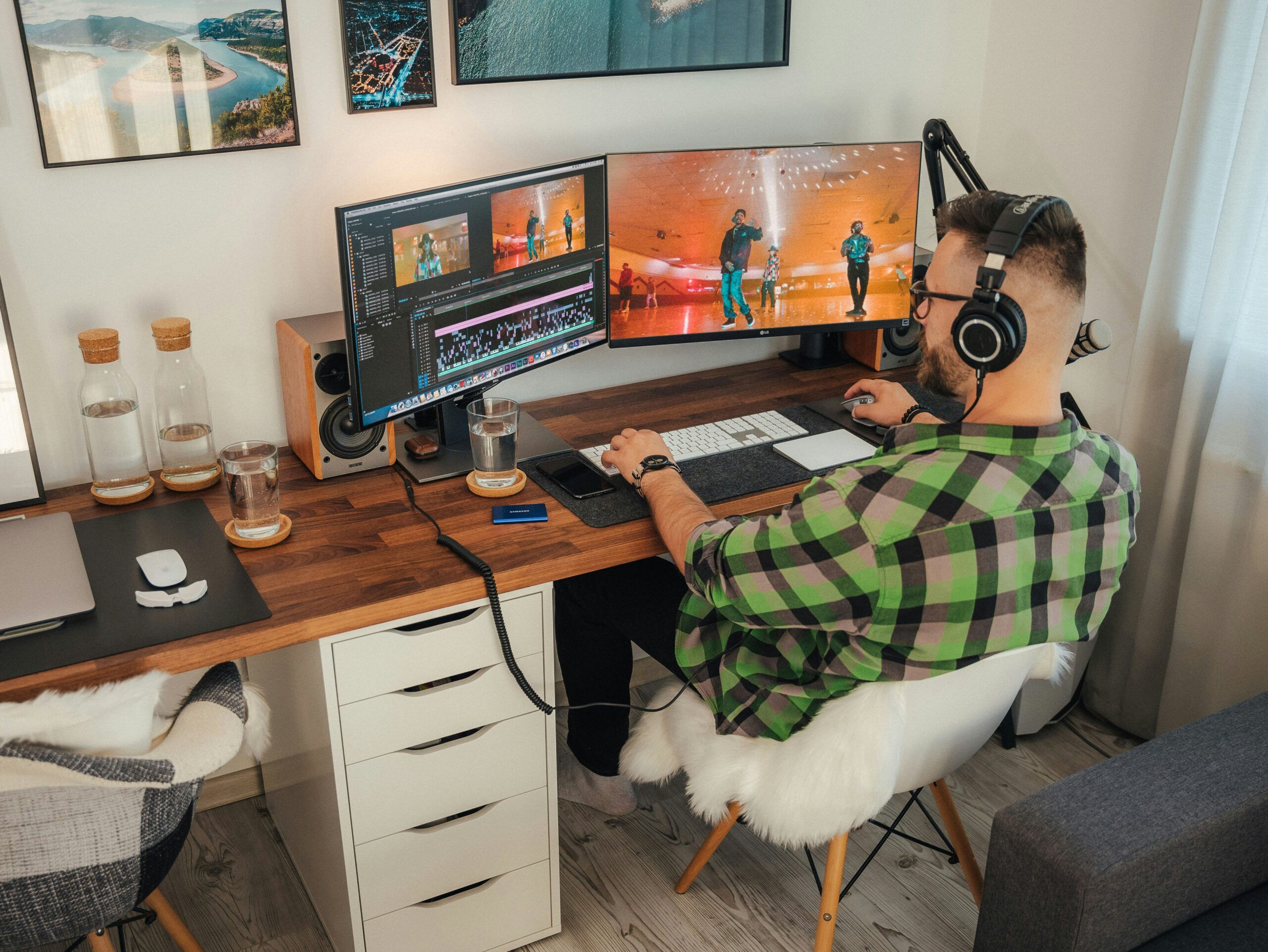 a person sitting at a desk with a computer and a dog