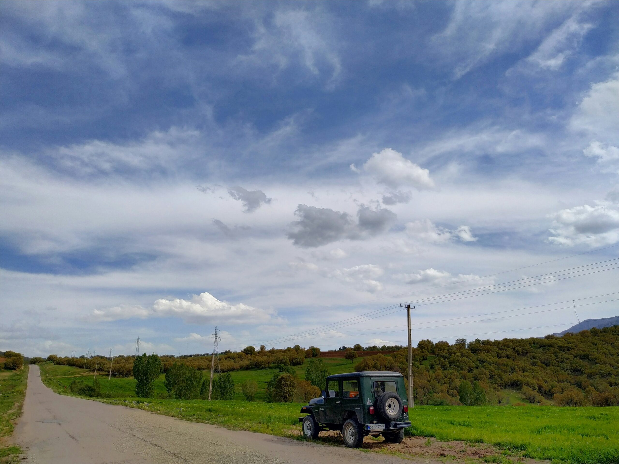 blue and black truck on road under cloudy sky during daytime