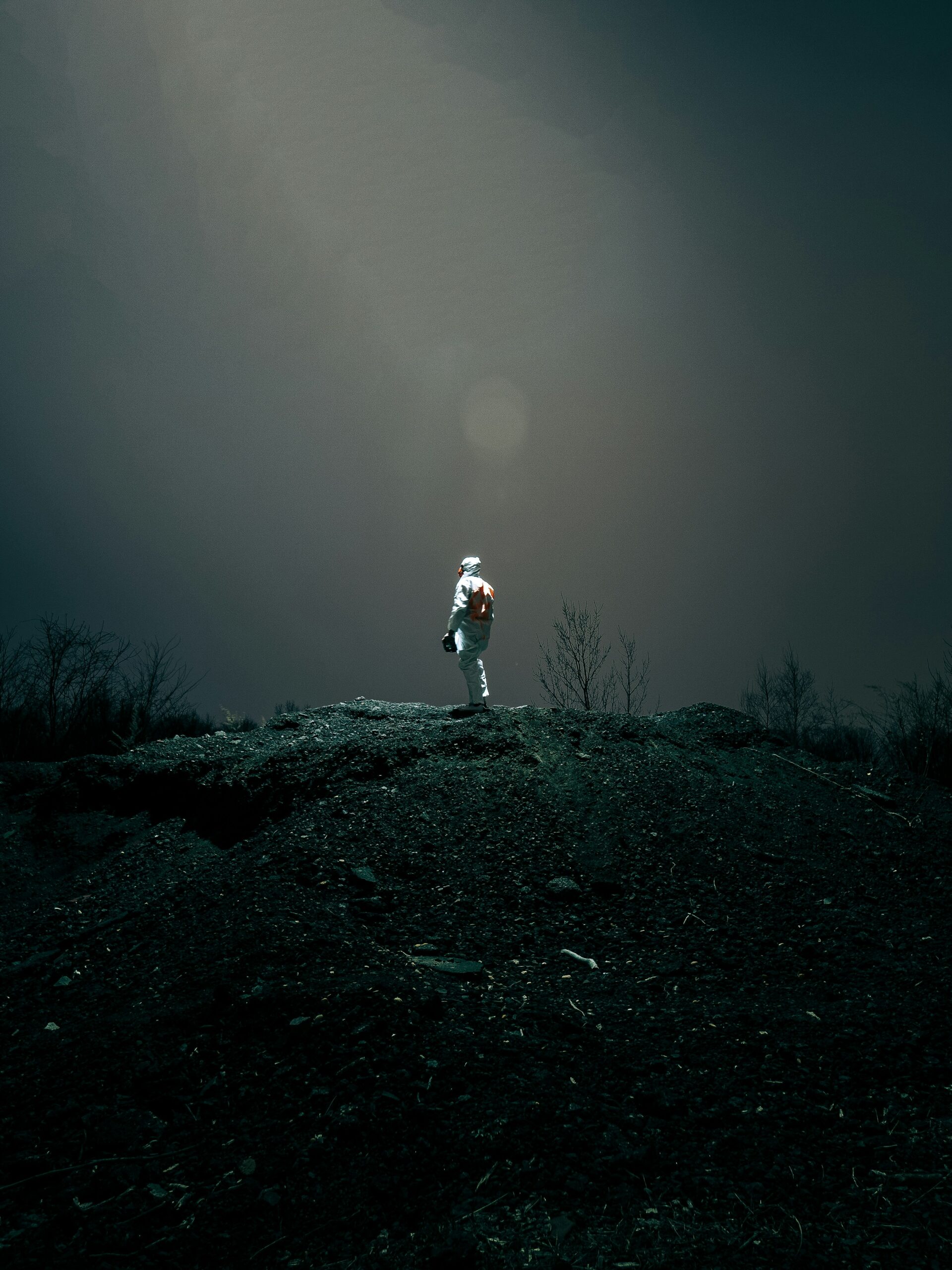 person in white jacket and pants standing on ground covered with snow during daytime